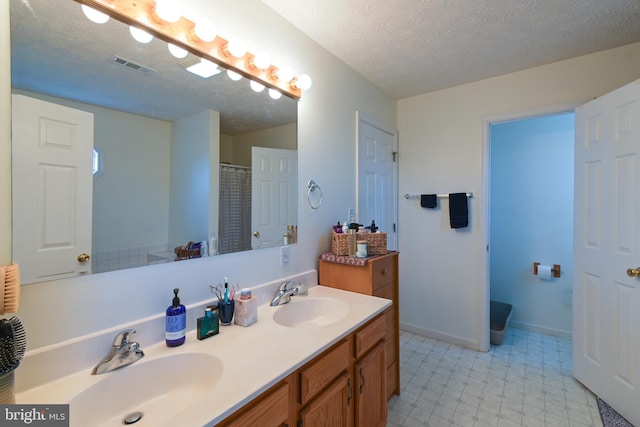 bathroom with vanity and a textured ceiling