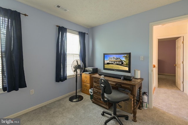 home office with a textured ceiling and light colored carpet