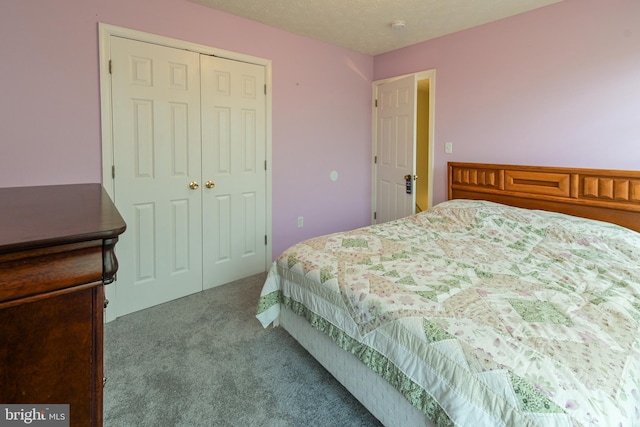 bedroom featuring a textured ceiling, light colored carpet, and a closet