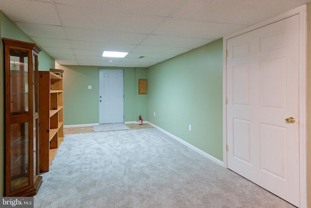 basement featuring a drop ceiling and carpet floors