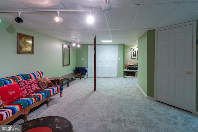 interior space featuring a paneled ceiling, carpet floors, and rail lighting