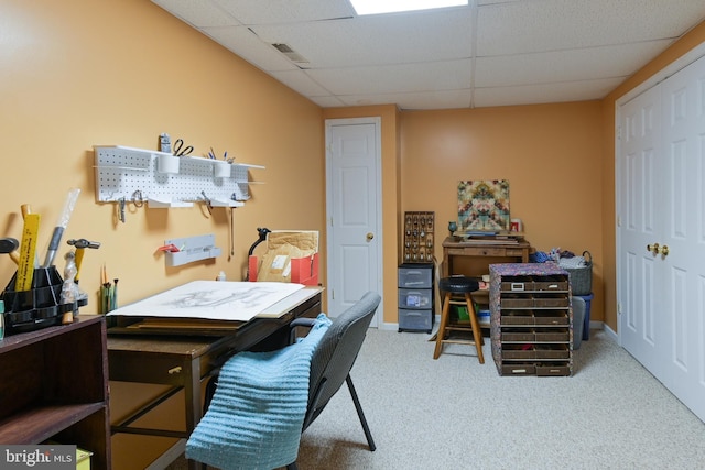 carpeted home office featuring a drop ceiling