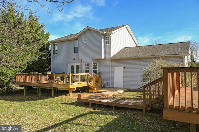 rear view of house featuring a lawn and a wooden deck