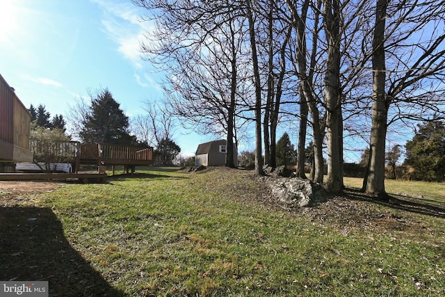 view of yard featuring a shed and a wooden deck