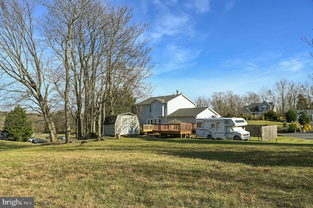 view of yard featuring a storage unit and a deck