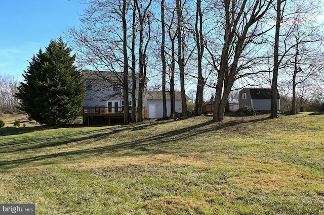 view of yard with a wooden deck and an outbuilding