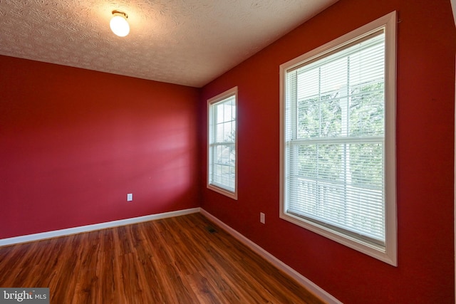 empty room featuring a textured ceiling and hardwood / wood-style flooring