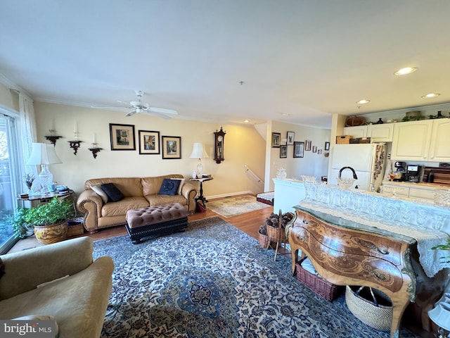 living room with hardwood / wood-style floors, ceiling fan, and ornamental molding