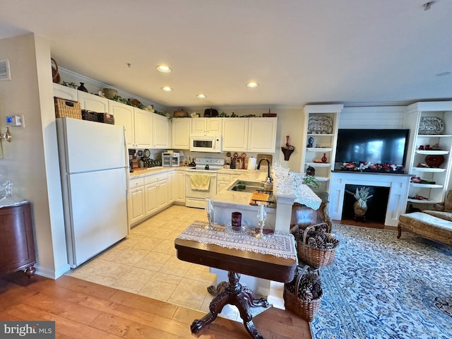 kitchen featuring white cabinets, white appliances, sink, and light hardwood / wood-style flooring