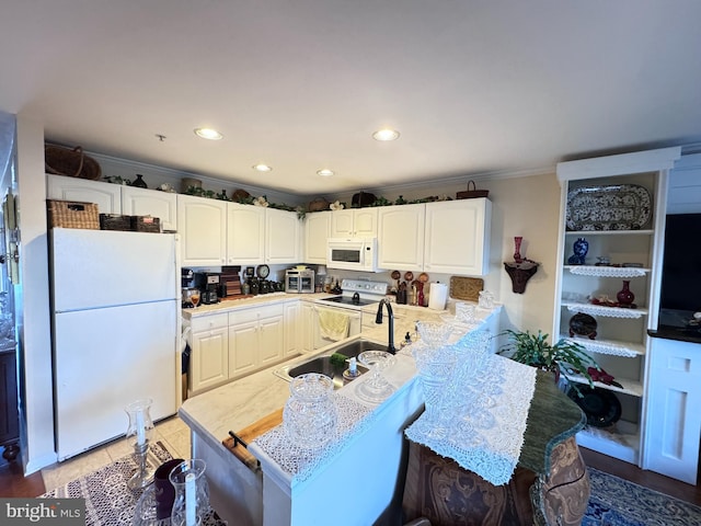 kitchen featuring white cabinets, white appliances, crown molding, and kitchen peninsula