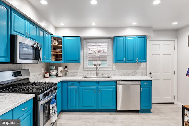 kitchen featuring blue cabinetry, appliances with stainless steel finishes, and sink