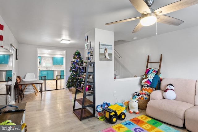 recreation room featuring ceiling fan, light hardwood / wood-style flooring, and sink