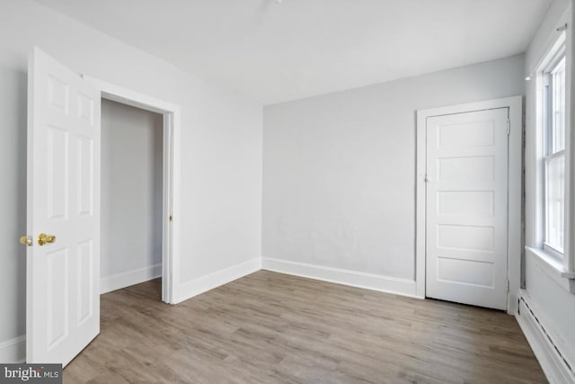 unfurnished bedroom featuring multiple windows and light hardwood / wood-style flooring