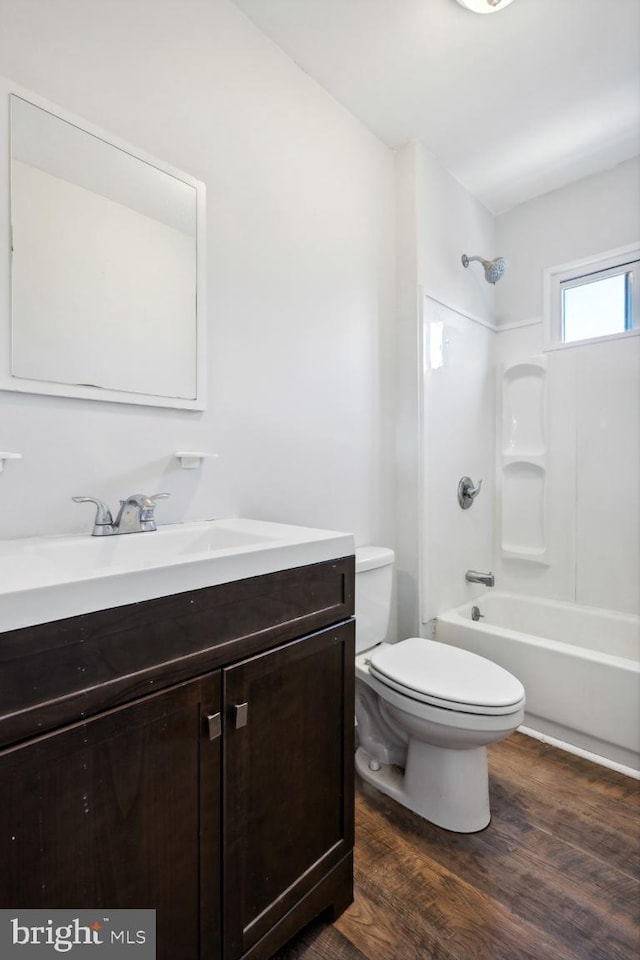 full bathroom with  shower combination, hardwood / wood-style flooring, vanity, and toilet