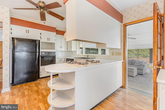 kitchen featuring ceiling fan, kitchen peninsula, light hardwood / wood-style floors, white cabinets, and black appliances