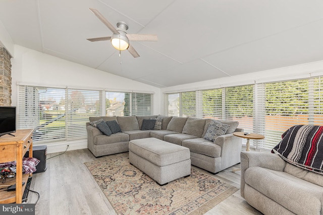 living room featuring vaulted ceiling, light hardwood / wood-style flooring, and ceiling fan