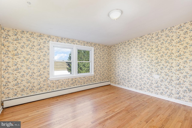 unfurnished room featuring light hardwood / wood-style flooring and a baseboard radiator