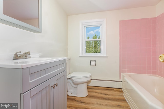 full bathroom featuring hardwood / wood-style floors, vanity, tiled shower / bath combo, toilet, and a baseboard radiator