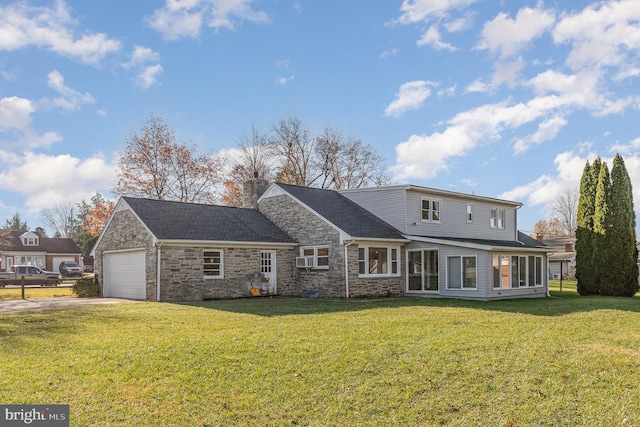 rear view of house with a lawn and a garage