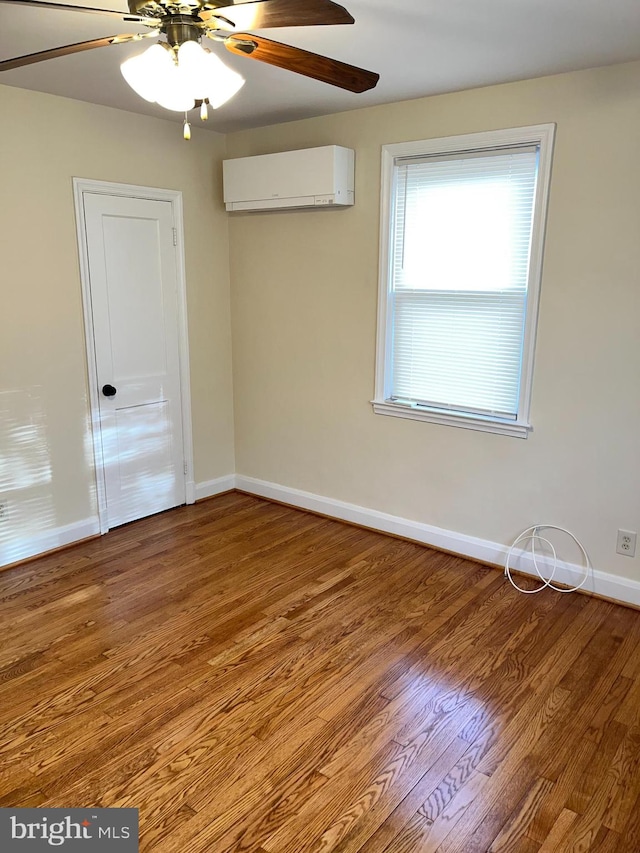 unfurnished room with hardwood / wood-style flooring, ceiling fan, and a wall mounted air conditioner