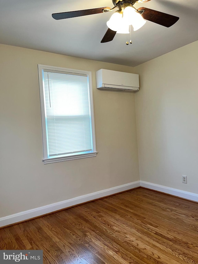 spare room featuring hardwood / wood-style floors, a wall mounted AC, and ceiling fan