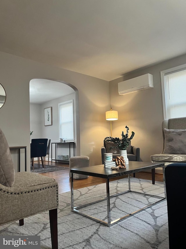 living room with hardwood / wood-style flooring and a wall mounted air conditioner