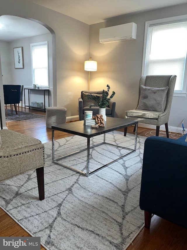 living room featuring hardwood / wood-style floors and a wall mounted air conditioner