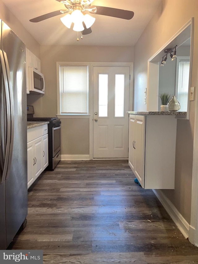 kitchen featuring white cabinetry, stainless steel appliances, dark hardwood / wood-style floors, and light stone counters