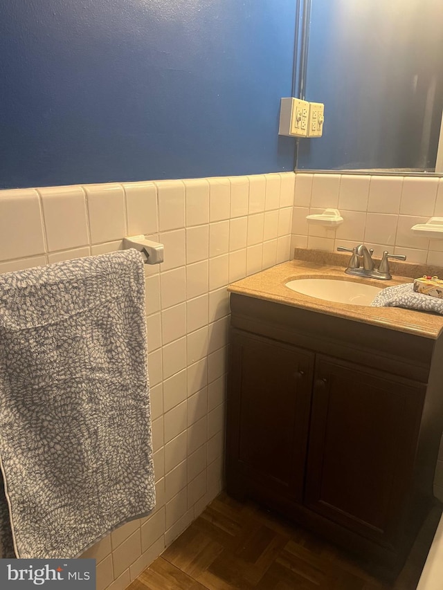 bathroom with vanity, tile walls, and parquet flooring