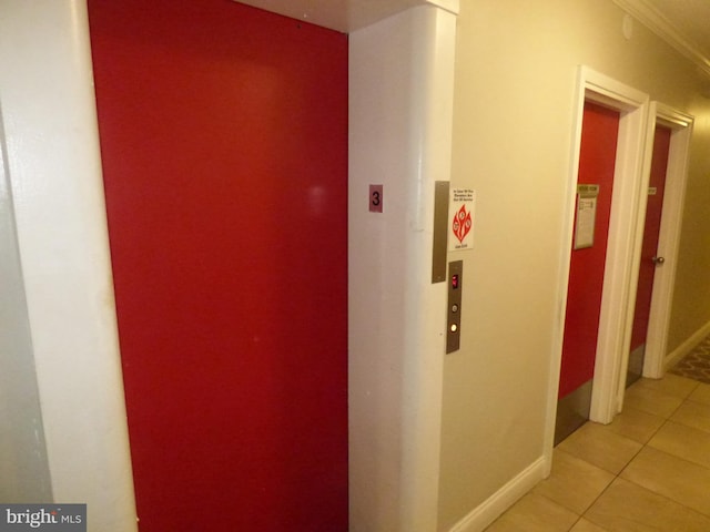 hallway featuring ornamental molding, elevator, and light tile patterned floors