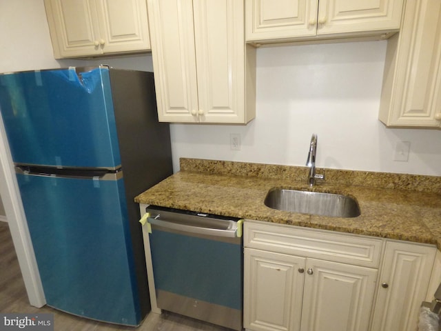 kitchen with stainless steel appliances, hardwood / wood-style flooring, sink, and light stone counters