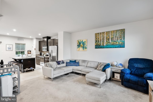 living room with sink and light carpet