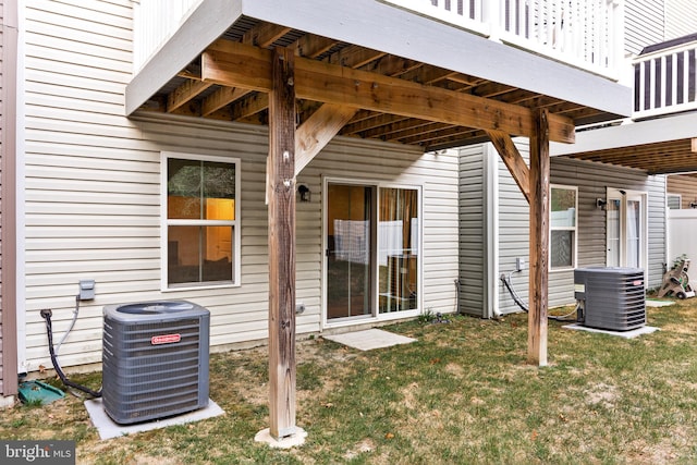 rear view of property featuring central air condition unit, a yard, and a deck