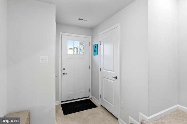 doorway to outside with light tile patterned flooring