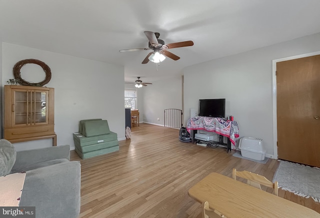 living room featuring light hardwood / wood-style floors and ceiling fan