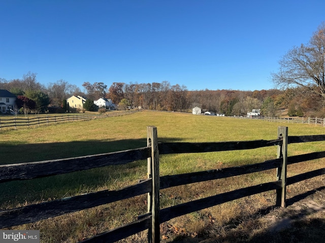 view of gate with a rural view and a yard