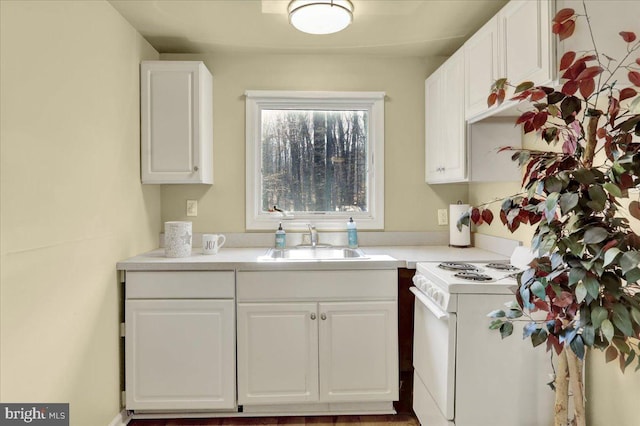 kitchen with white range with electric stovetop, white cabinetry, and sink