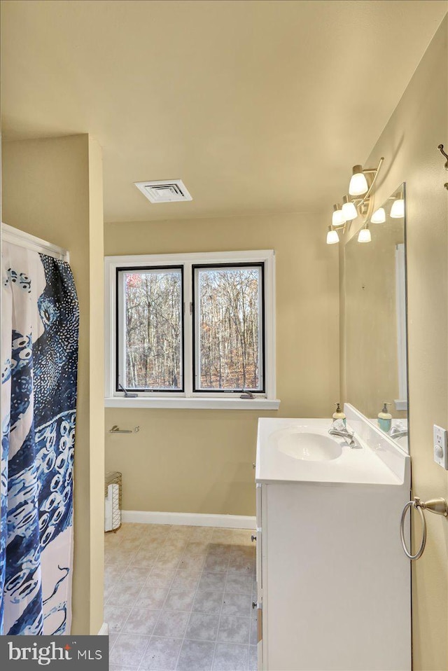 bathroom featuring tile patterned floors, vanity, and a chandelier