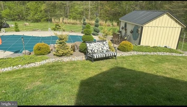 view of yard featuring a covered pool and a storage shed