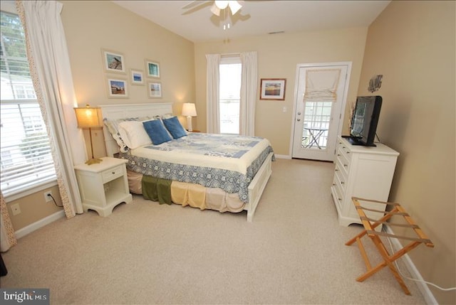 carpeted bedroom featuring ceiling fan, multiple windows, and access to exterior