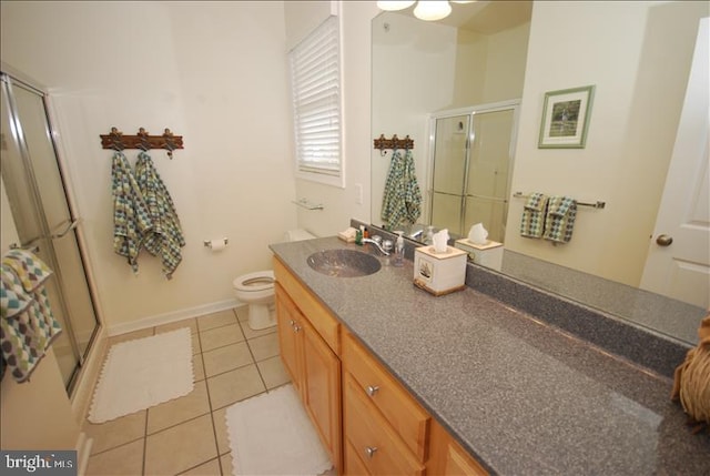 bathroom featuring tile patterned floors, vanity, toilet, and a shower with door