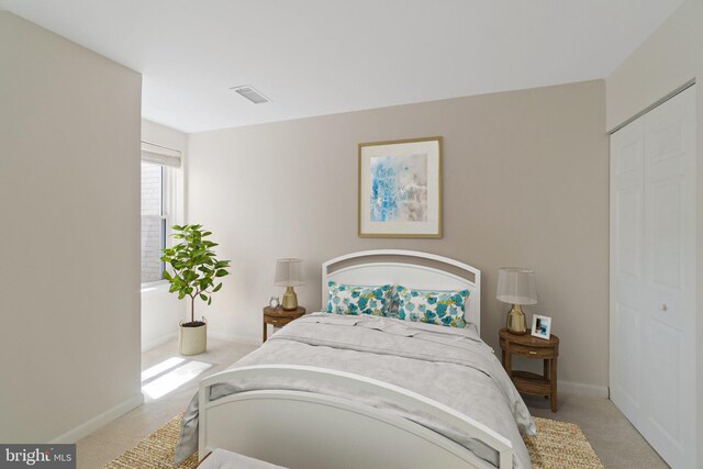 bedroom with light colored carpet and a closet