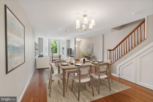 dining area featuring hardwood / wood-style floors and a notable chandelier