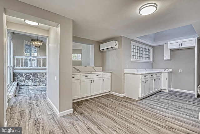 kitchen with white cabinetry, a healthy amount of sunlight, and light hardwood / wood-style floors