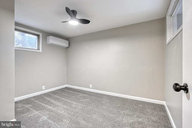 spare room featuring an AC wall unit, carpet, and ceiling fan