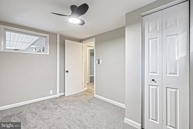 unfurnished bedroom featuring carpet floors, ceiling fan, and a closet