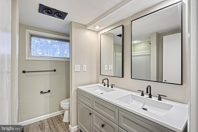 bathroom with hardwood / wood-style floors, vanity, and toilet