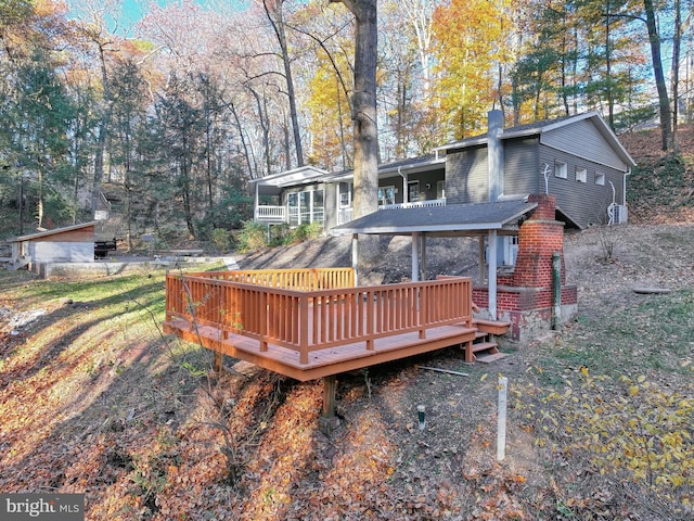 rear view of property featuring a wooden deck