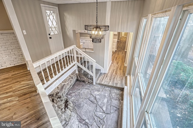 foyer with wood-type flooring and a notable chandelier