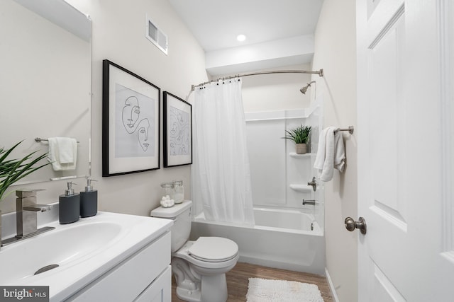 full bathroom featuring hardwood / wood-style floors, shower / tub combo with curtain, vanity, and toilet